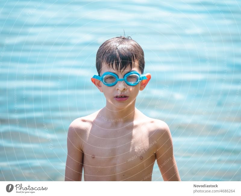 Porträt eines kaukasischen 6-jährigen Jungen am Strand mit Schwimmbrille, Sommerferien Konzept vereinzelt Feiertage Urlaub Kaukasier 6 Jahre alt Kind im Freien