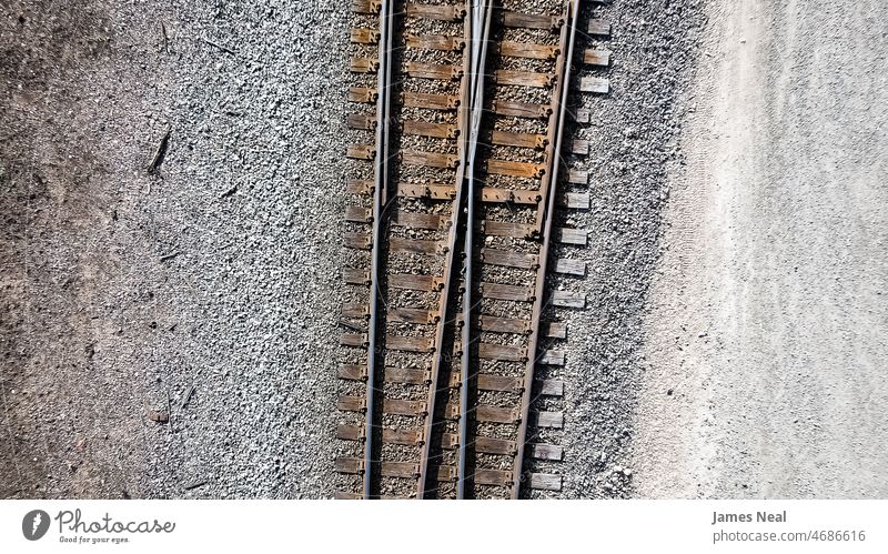 Luftaufnahme von zwei alten, rostigen Eisenbahnschienen. Bahn Oberfläche Kies industriell Industrie Verkehr Boden Spuren flach Ansicht oben Grunge Straße