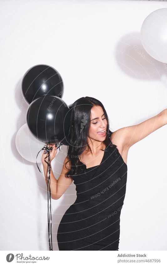 Attraktive Frau mit schwarzen und weißen Luftballons Geburtstag feiern Feiertag Stil Veranstaltung festlich Lächeln Mode schwarzes Kleid Augen geschlossen