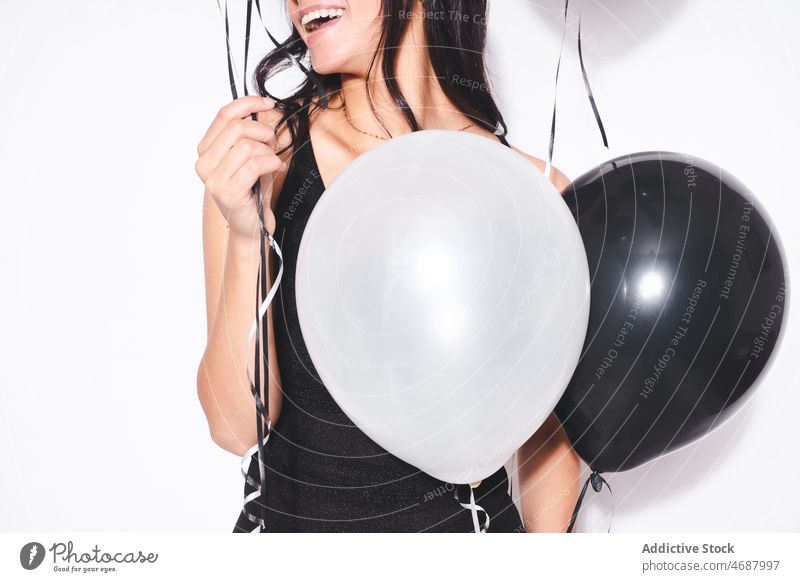 Anonyme attraktive Frau mit schwarzen und weißen Luftballons Geburtstag feiern Feiertag Stil Veranstaltung festlich Lächeln Mode schwarzes Kleid feminin