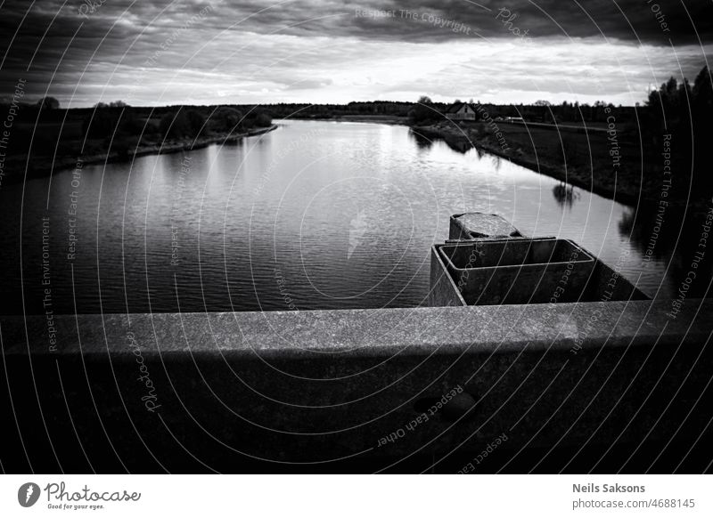 Ein guter Platz, um das Wasser zu beobachten. Fluss Lielupe, Lettland, in der Nähe der Stadt Jelgava. Dunkle pessimistische Version Brücke Geländer nach oben