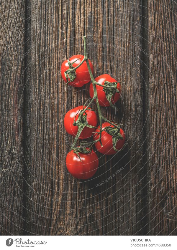 Nahaufnahme von roten Tomaten auf dunklem, rustikalem Holzhintergrund. abschließen dunkel hölzern Hintergrund saisonbedingt Gesundheit Sommer Gemüse Draufsicht