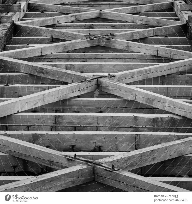 Balkenwerk Holz Holzbalken Bau bauen Zimmermann Zimmermannskunst kreuz quer diagonal kruez und quer parallel eisen Schrauben Muster Hintergrund Textur sw