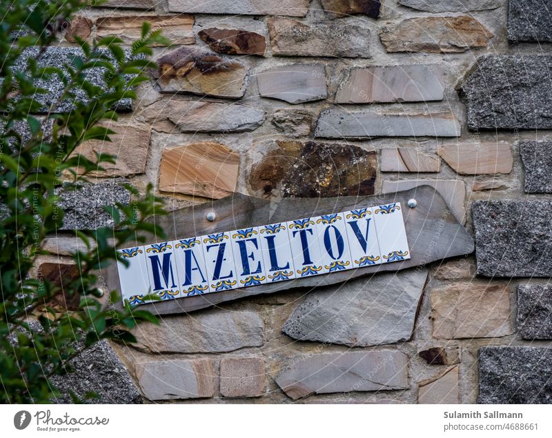 Schild mit der Aufschrift "Mazeltov" ZEICHEN mazeltov symbol text typo mazel tov jüdisch jiddisch Masel tov hebräisch Buchstaben Zeichen Wort Text Typographie