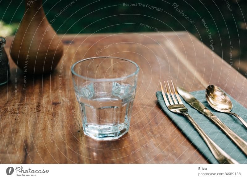 Wasserglas mit Besteck auf Holztisch leitungswasser Tisch Glas Trinkwasser Durst Restaurant gedeckt golden Trinkglas