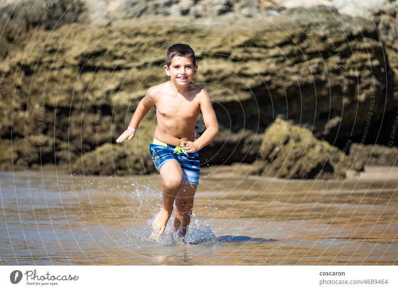 Kleines Kind läuft auf einem felsigen Strand aktiv Aktivität Baby blond Junge Cadiz cala del aceite Kaukasier Kindheit Küste konil niedlich Energie genießen