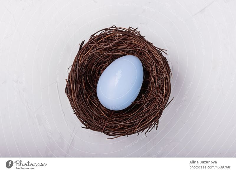 Stilvoller Hintergrund mit bunten Ostereiern im Nest isoliert auf grauem Betonhintergrund. Flat Lay, Draufsicht, Mockup, Overhead, Vorlage. Ostern Ei