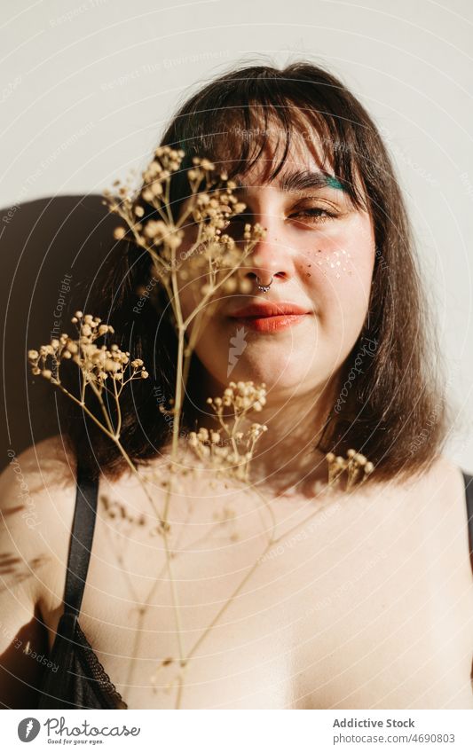 Übergewichtige Frau in Unterwäsche mit Trockenblumen Übergröße getrocknet Zweig Blume Figur Sonnenlicht Lächeln Dessous Raum genießen feminin Freude heimwärts