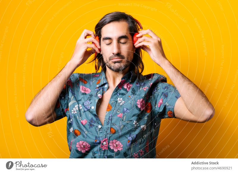Mann hört Musik mit Kopfhörern meloman Gesang zuhören Klang Hobby Zeitvertreib Porträt Stil Drahtlos geblümt lebhaft männlich Melodie Typ farbenfroh modern