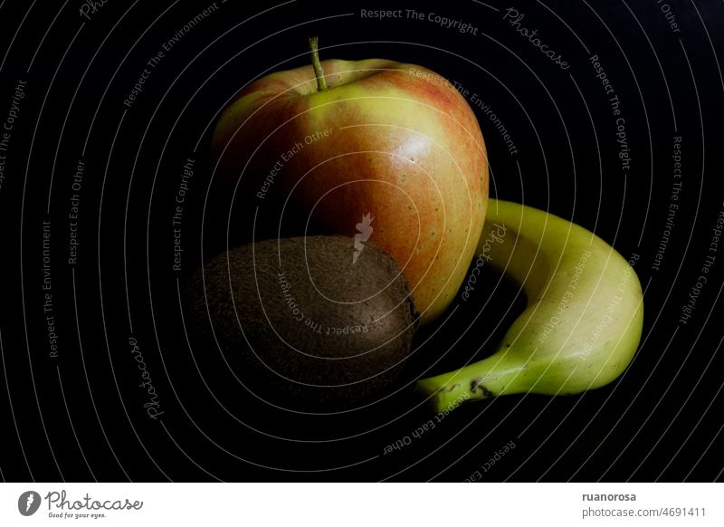 Stimmungsvolles Stillleben mit Apfel, Banane und Kiwi düstere Stimmung Früchte Frucht saftig Lebensmittel Kontrast Ernährung frisch Gesunde Ernährung schwarz