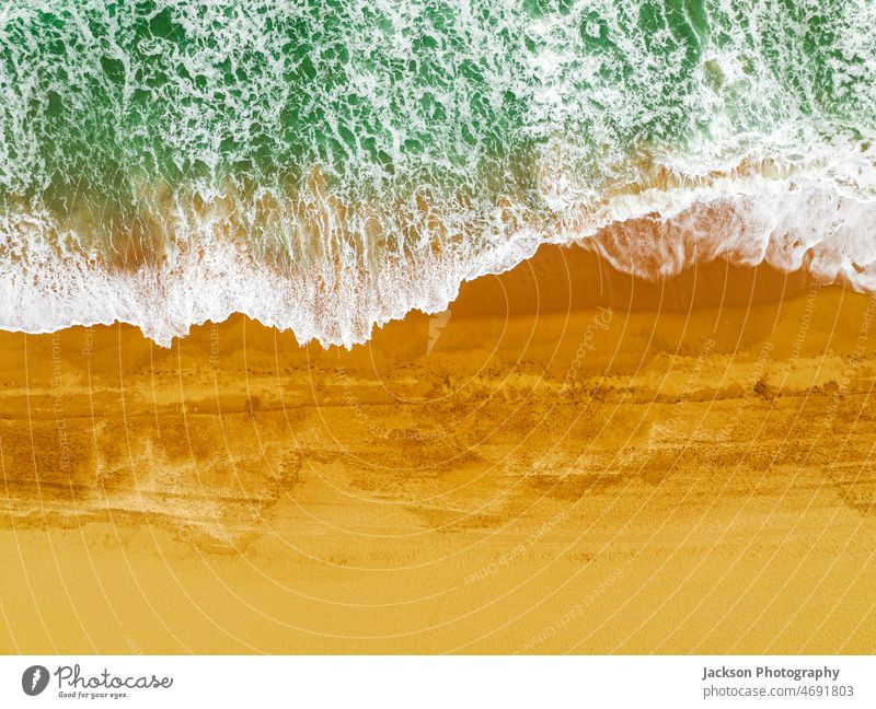 Draufsicht auf Wellen, die am Sandstrand von Albufeira, Algarve, Portugal, brechen Meer Strand Natur Textfreiraum pulsierend im Freien Naturhintergrund sandig