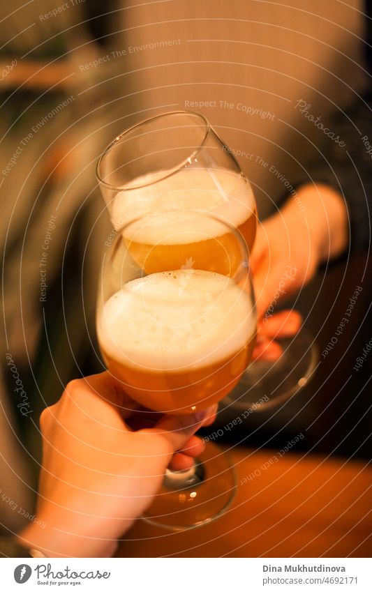 Freunde, die mit Biergläsern anfeuern, Bier oder Apfelwein zusammen mit Freunden an der Bar trinken Alkohol Getränk Bierglas Farbfoto Durst Alkoholsucht