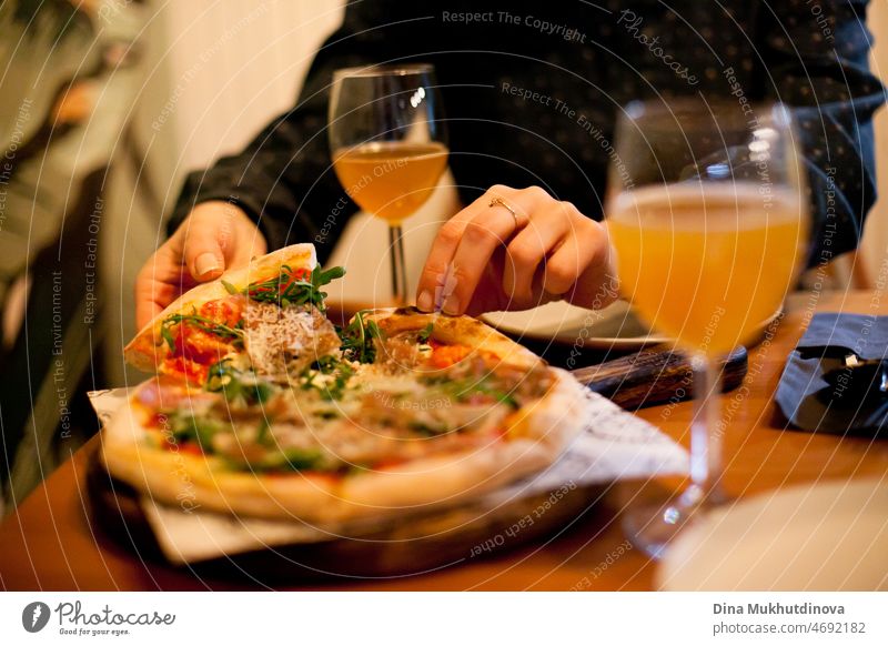 Pizza und Gläser von Craft Beer Nahaufnahme auf dem Tisch. Pizza essen und Bier trinken mit einem Freund in einer Pizzeria oder bei einem Date im Restaurant. Essen und Trinken. Leckere Mahlzeit.