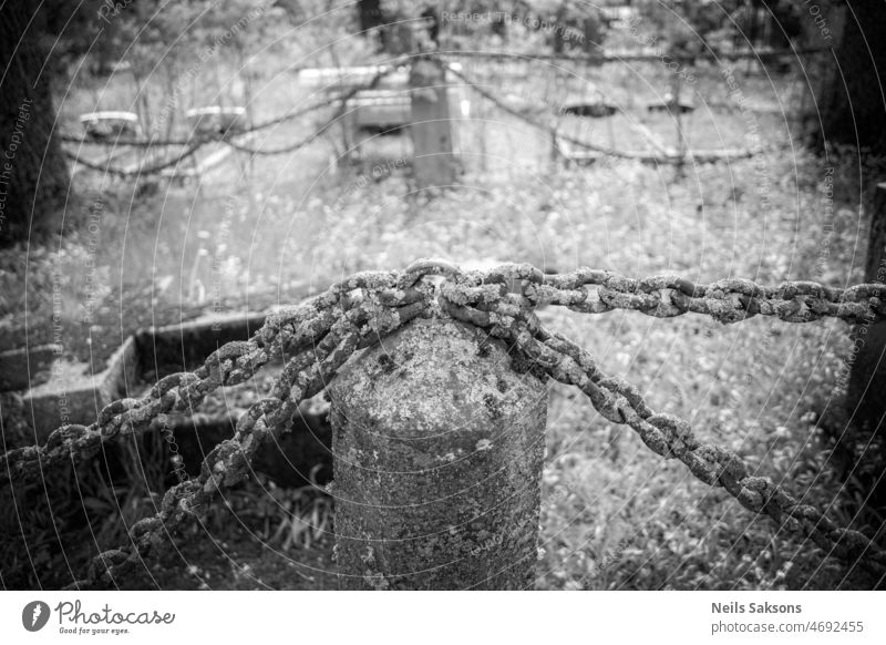 Kettenzaun mit Granitsäulen auf dem alten lettischen Friedhof Schönheit schwarz anketten Großstadt Landschaft Tag Zaun Wald für immer Gras Grab Grabumrandung