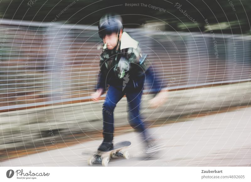 Junge fährt auf Skateboard auf dem Gehsteig, als Mitzieher verwischt Bewegung Unschärfe Skateboarding Freude sportlich Lifestyle fahren Kind Kindheit