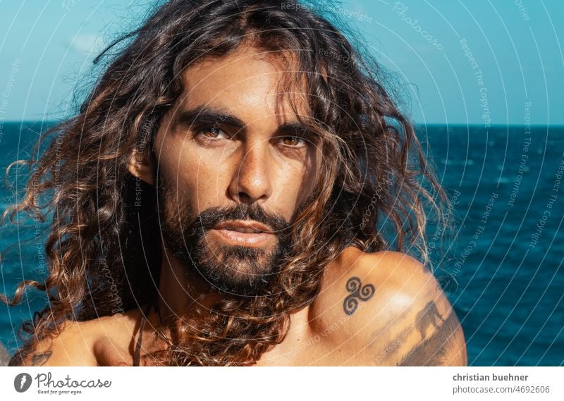 Porträts eines 35 Jahre alten Mannes mit langen Haaren Junger Mann lange Haare krause Haare nackter Torso Latin Lover erotisch Hippie selbstgenügsam Damenbart