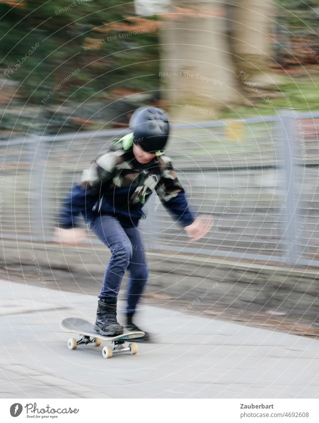 Junge fährt auf Skateboard auf dem Gehsteig, als Mitzieher verwischt Bewegung Unschärfe Skateboarding Freude sportlich Lifestyle fahren Kind Kindheit