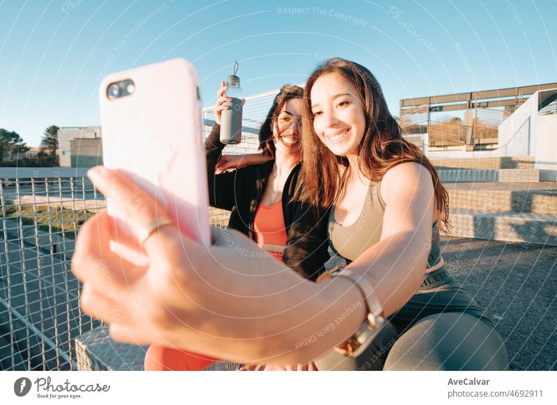 Zwei junge sportliche Frau Freunde nehmen Selfies mit Smartphone zwischen Übungen zu zeigen, auf Social Media. Training Gewicht verlieren mit Freunden zusammen lächelnd in die Kamera glücklich. Schwestern Konzept