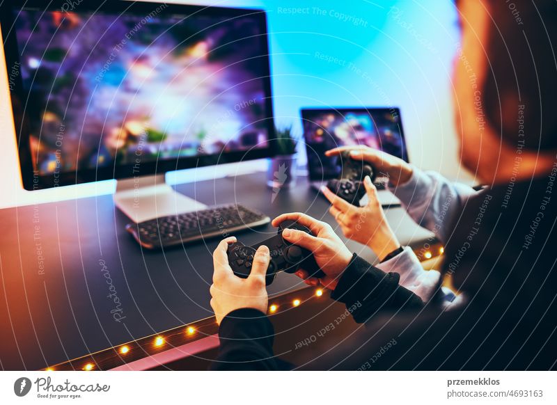 Freunde spielen ein Videospiel zu Hause. Spieler, die online in einem dunklen, von Neonröhren beleuchteten Raum spielen. Wettbewerb und Spaß haben Spielen