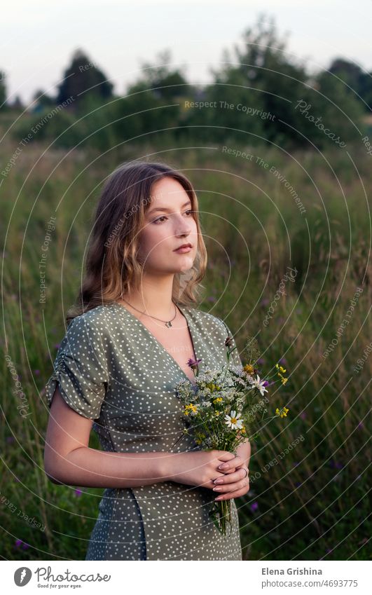 Schönes Mädchen hält einen Strauß Wildblumen in den Händen Feld Blumen Ruhe Frieden Harmonie Einsamkeit Kleid rustikaler Stil Seelenfrieden