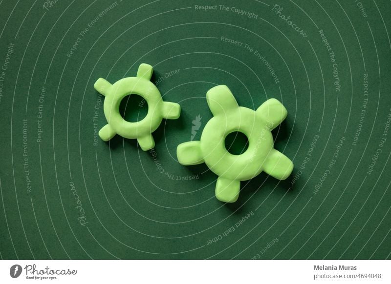 Zwei 3d-Zahnräder in verschiedenen Größen auf grünem Hintergrund. Mechanismus-Elemente, Konzept des Fortschritts, Teamarbeit. Brainstorming Business Zahnrad