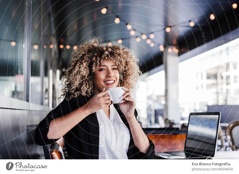 schöne afroamerikanische Geschäftsfrau in einem Café, die an einem Laptop und einem Mobiltelefon arbeitet, Business und Technik Computer Afro-Look Frau arbeiten
