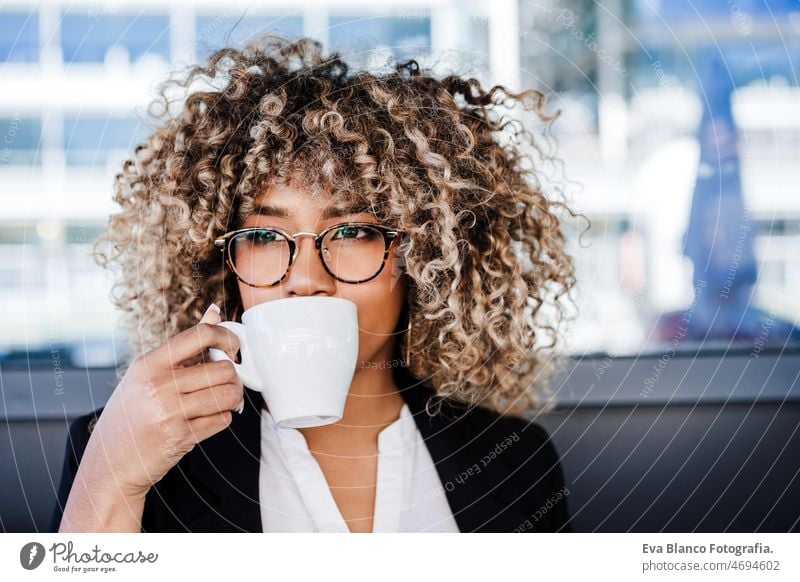 schöne hispanische Afro-Geschäft mit Brille trinken Kaffee in der Cafeteria. Business-Konzept Afro-Look Frau Café Laptop arbeiten Vernetzung Terrasse im Freien