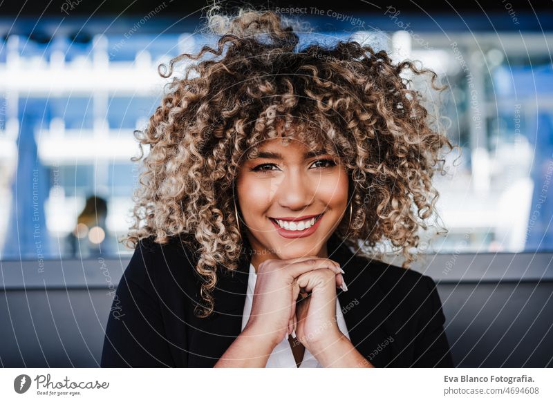 Porträt einer lächelnden, zuversichtlichen Geschäftsfrau in einem Café. Business-Konzept Afro-Look Frau hispanisch Terrasse Lächeln Glück Handy Großstadt