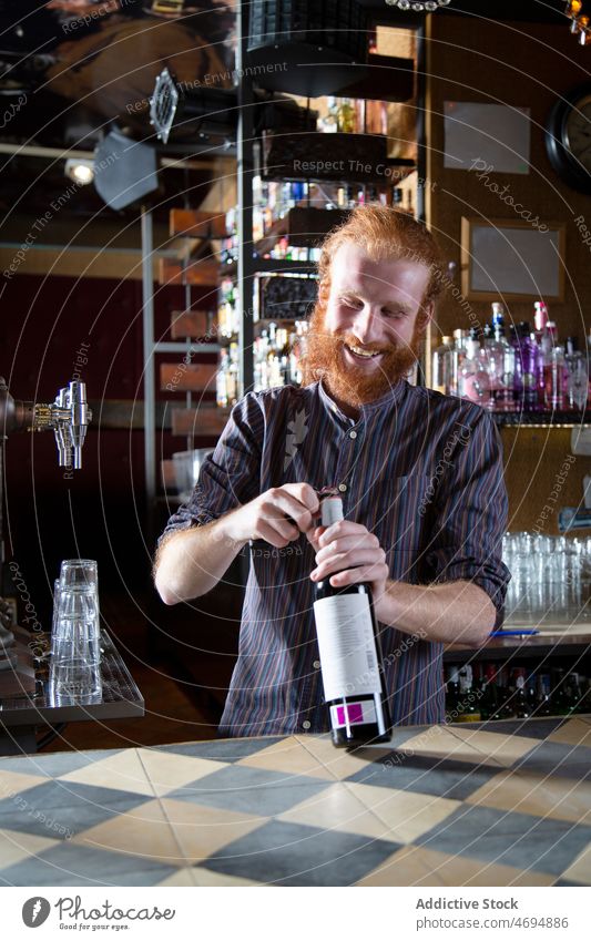 Bärtiger Barkeeper öffnet Weinflasche Mann Alkohol Aperitif Getränk Arbeit trinken Flasche Barmann offen männlich professionell Inhalt Beruf
