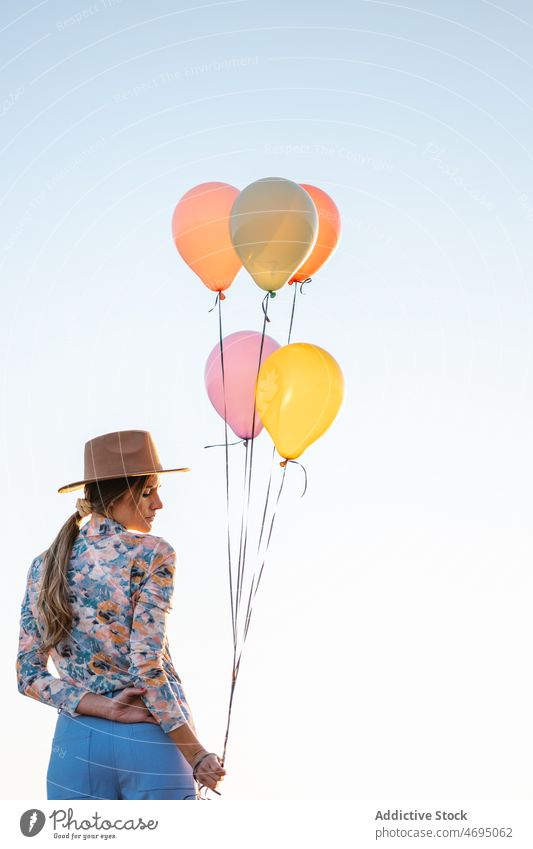 Anonyme Frau mit Luftballons gegen klaren Himmel Landschaft Natur Stil Klarer Himmel Hut farbenfroh Sommer hell Outfit Hafengebiet Ambitus Freizeit Abend