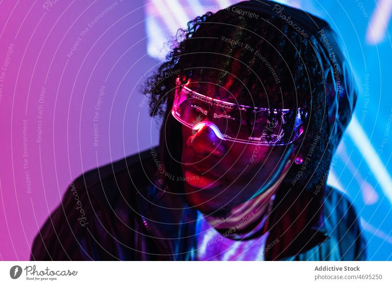 Schwarzer Mann mit futuristischer Brille Cyberpunk Zukunft Hochtechnologie trendy modern Wand Windstille glühen männlich schwarz Afroamerikaner Zeitgenosse Typ
