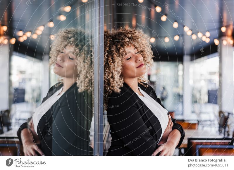 Porträt einer entspannten Geschäftsfrau mit geschlossenen Augen in einem Café, die sich an ein Glas lehnt. Business-Konzept Laptop Computer Afro-Look Frau