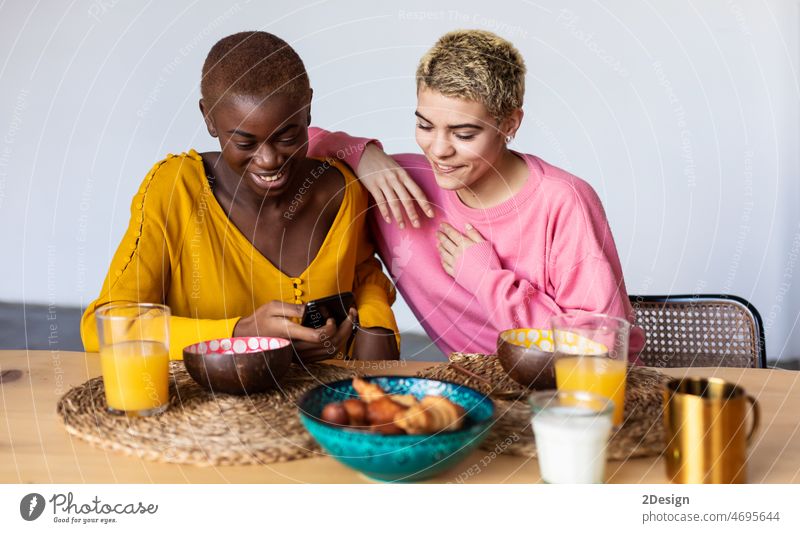 Glückliche multiethnische Mädchen telefonieren beim Mittagessen Person Abendessen Lebensmittel Lifestyle Tisch Technik & Technologie Frau Mahlzeit Mobile