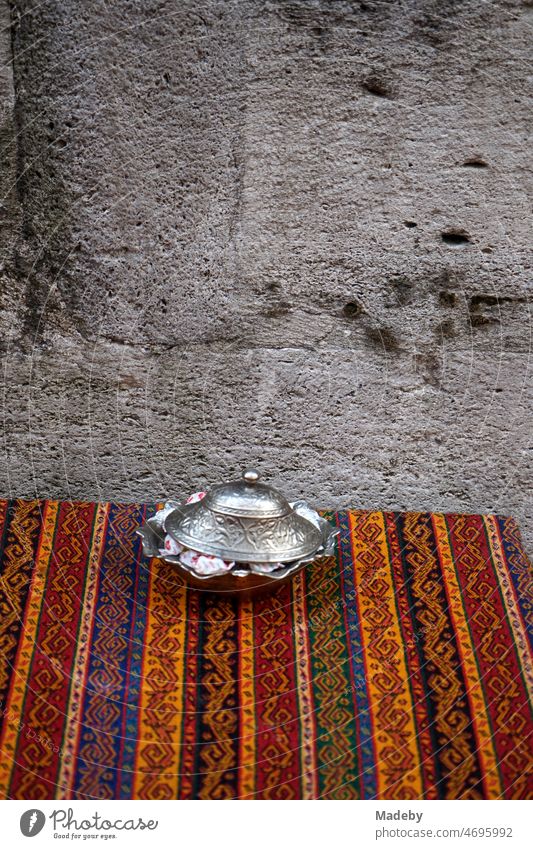 Traditionelle gestreifte orientalische Tischdecke auf dem Tisch eines Teehaus in der Altstadt von Eminönü im Sommer in Istanbul am Bosporus in der Türkei alt