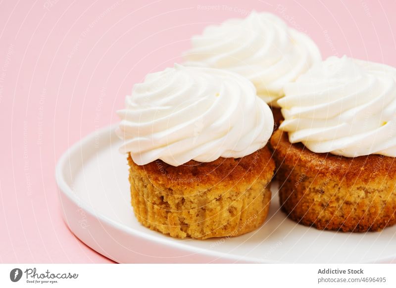 Süße Cupcakes mit weißem Zuckerguss Dessert süß Konfekt Gebäck Konditorei Belag Leckerbissen Sahne Vanille Lebensmittel frisch geschmackvoll lecker appetitlich