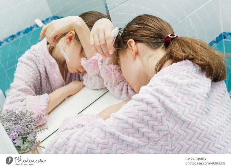 schlafendes Teenager-Mädchen mit einer Zahnbürste in der Hand schläfrig früher Morgen müde überdrüssig Halt Nachtruhe Finger Rücken Lügen stehen Regal Abend