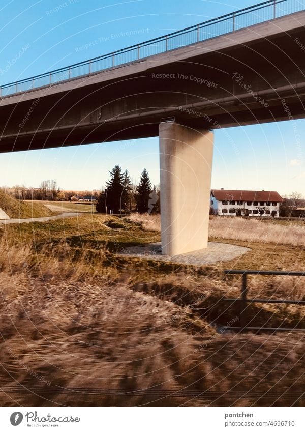 Eine Autobahnbrücke, Straßenbrücke in idyllischer Landschaft vom zug aus fotografiert. Blauer himmel Zugfahrt landschaft autobahnbrücke straßenbrücke