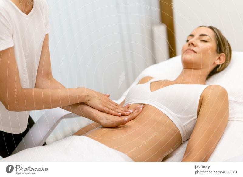 Frau mittleren Alters bei einer Bauchmassage in einem Schönheitssalon. Massage Unterleib Menschen Spa Körper sich[Akk] entspannen massierend Masseur