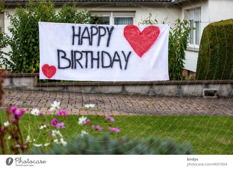 Happy birthday. Geburtstagsgruß mit Schrift und roten Herzen auf einem weißen Tuch im Garten eines Hauses Happy Birthday Geburtstagswunsch Feste & Feiern