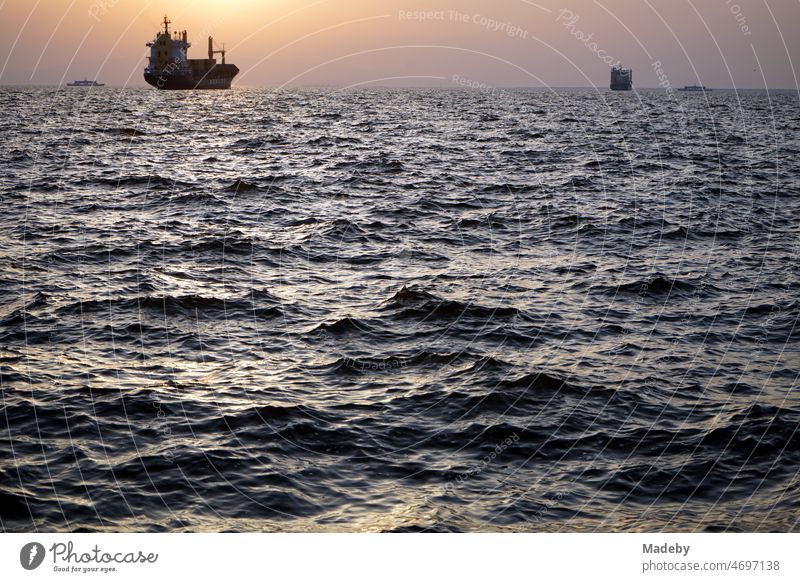 Ankerndes Frachtschiff in der Bucht von Izmir im Licht der untergehenden Sonne über dem Ägäischen Meer im Sommer in der Türkei Heimat Touristik Tourismus