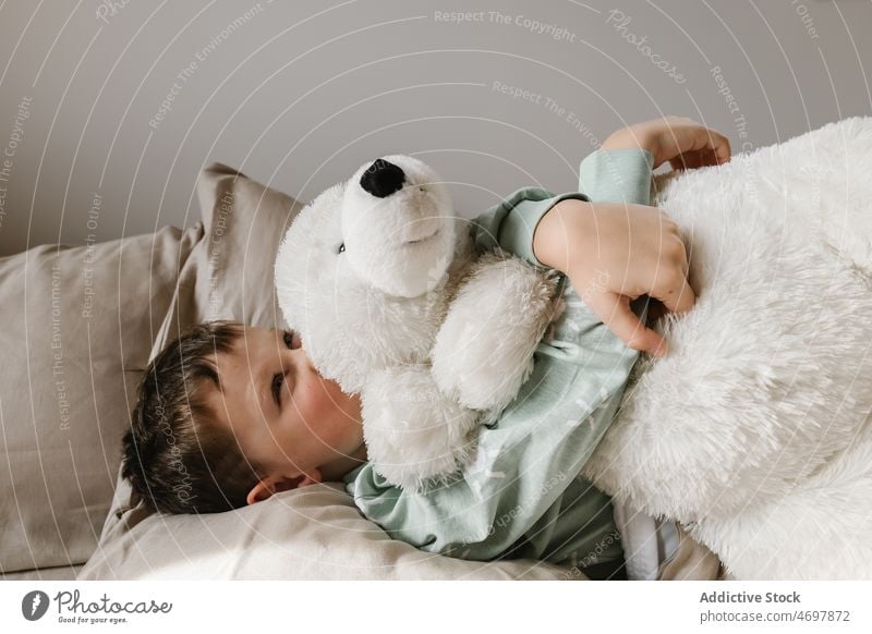 Niedliches Mädchen mit Spielzeug auf dem Bett Kind Kindheit Schlafzimmer Morgen heimisch Schlafenszeit Pyjama Bär gemütlich Umarmen Appartement Lächeln