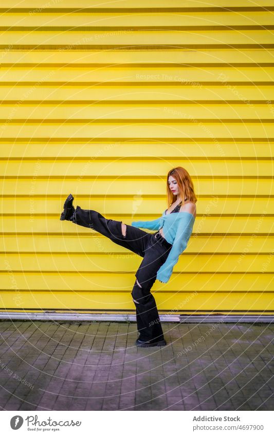 Trendy Frau hebt Bein auf der Straße trendy Stil Streetstyle Wand Großstadt Vorschein sorgenfrei Bein angehoben Mode Gleichgewicht Outfit charmant Körperhaltung