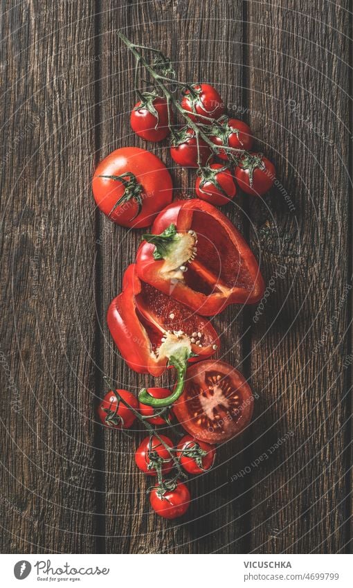 Komposition aus rotem Gemüse auf rustikalem Holzhintergrund Zusammensetzung hölzern Hintergrund roh Tomaten Paprika Küche Tisch Essen zubereiten Vorbereitung