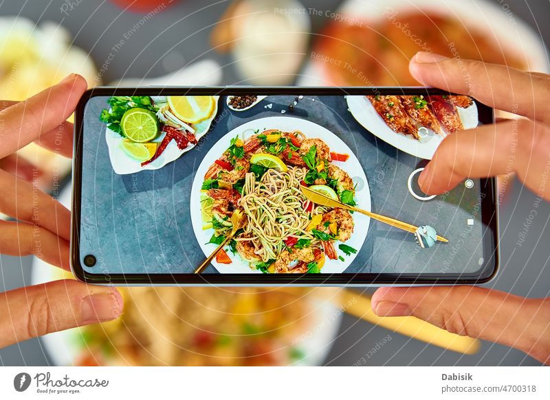 Foto von gebratenen Nudeln mit dem Smartphone für soziale Medien machen Lebensmittel Fotografie Wok soba asiatisch Telefon Ernährung Küche Mobile pov Restaurant