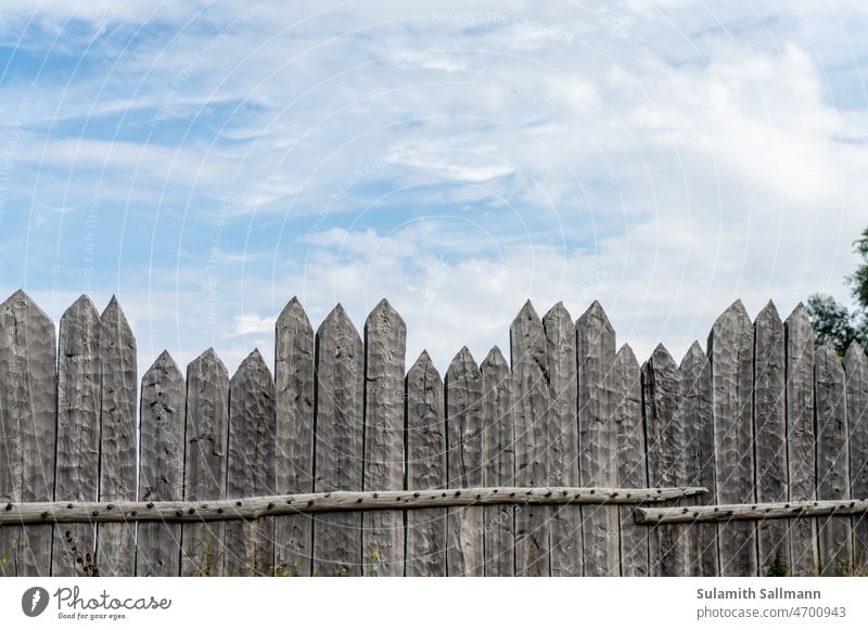 unregelmäßiger Lattenzaun historisch hölzern slawisch Begrenzung Sicherheit Einfriedung einfrieden einzäunen Zaun Holz Bretterzaun Außenaufnahme Farbfoto