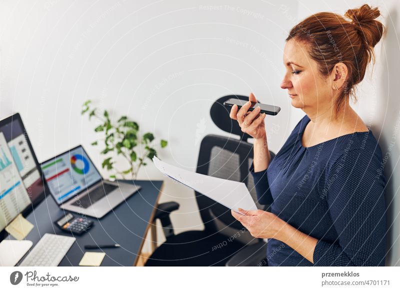 Unternehmerin führt ein Geschäftsgespräch am Handy. Geschäftsfrau arbeitet im Büro und hält Dokumente und Smartphone Business Anruf Gespräch Aufruf