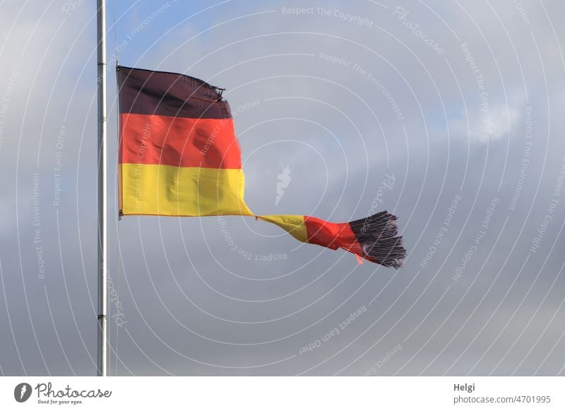 Teekesselchen | Fahne - vom Sturm zerfetzte Deutschlandflagge vor blaugrauem Himmel Flagge schwarz-rot-gold Fahnenstange kaputt Wind stürmisch zerrissen