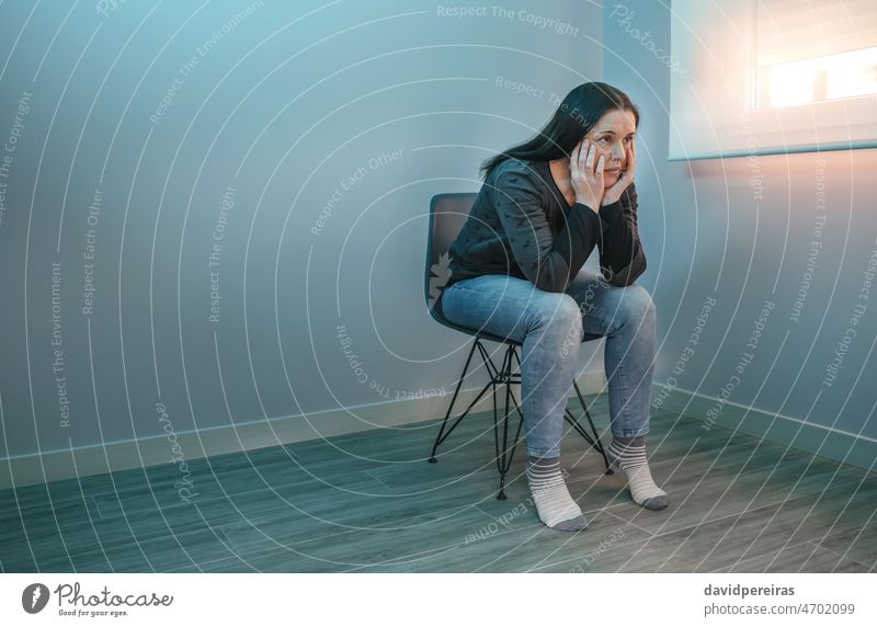 Nachdenkliche Frau mit verlorenem Blick sitzt auf einem Stuhl Sorge besinnlich verlorener Blick psychische Gesundheit Problematik Sitzen Unsicherheit Lehnen