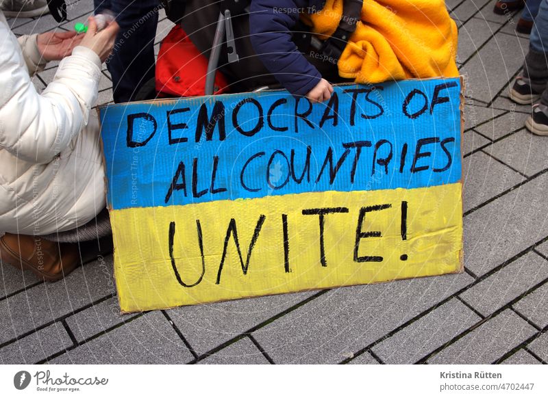 democrats unite plakat mit den ukrainischen nationalfarben countries demokraten aller länder vereinigt euch schild protest friedensdemo kundgebung demokratie