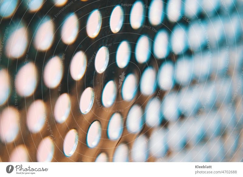 Edelstahllochblech mit hellem bläulichem Hintergrund - teilweise Unschärfe Lochblech künstlerisch bläuliche Farbgebung verschwommen Strucktur abstrakt Bokeh